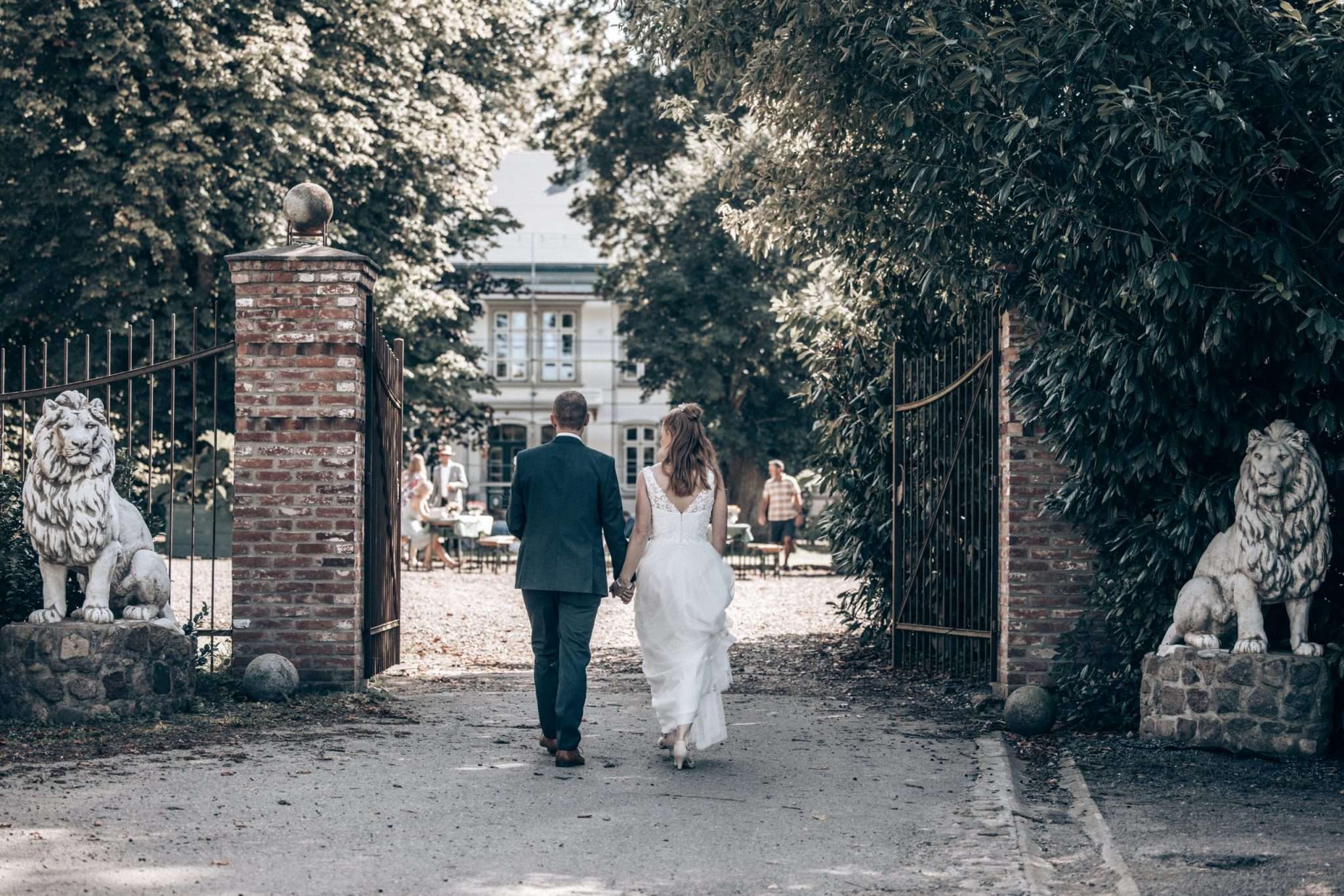 Hochzeitspaar geht durch das Tor.