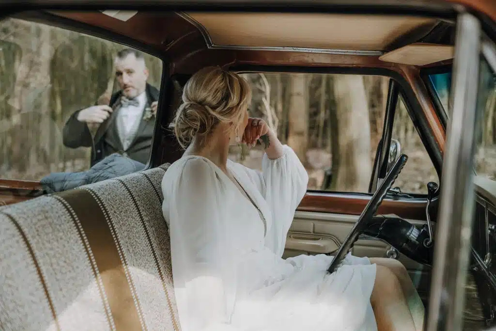 Brautpaar mit Oldtimer im Wald